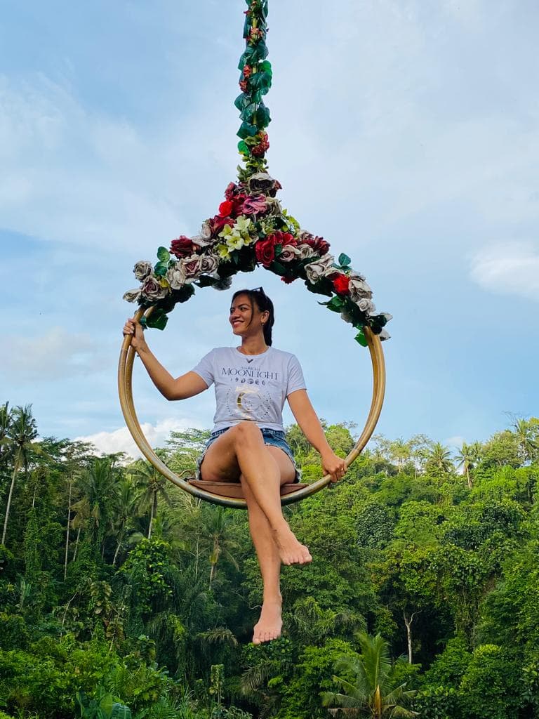 Déborah, coach Balance & Conseils, sur une balançoire fleurie en pleine nature
